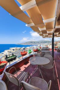 un balcón con mesas y sillas y el océano en Summer Dream Hotel, en Sarandë