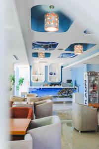 una sala de espera con sofás, mesas y techos azules en Summer Dream Hotel, en Sarandë