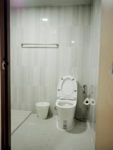 a white bathroom with a toilet and a sink at PD Apartment Inn in Ban Pra Dok