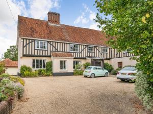 une maison avec deux voitures garées devant elle dans l'établissement John Fanner Barn - Uk37102, à Mellis