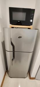 Un refrigerador con un microondas encima. en Departamento Temporario 54, en La Plata