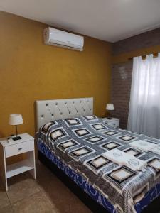 sypialnia z łóżkiem i dwoma stołami z lampkami w obiekcie Complejo M&M w mieście Bialet Massé