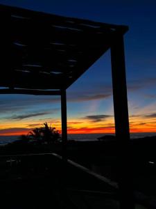 a view of a sunset from a house with the sky at Tres Velas Surf in Celestino Gasca