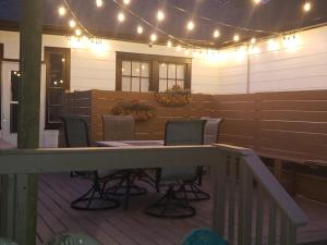 een patio met een tafel en stoelen op een terras met verlichting bij The Moise Manor in Sumter