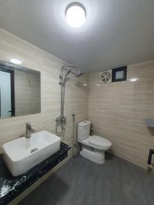 ein Badezimmer mit einem weißen Waschbecken und einem WC in der Unterkunft 89 Phạm Văn Đồng, Hà Nội in Hanoi