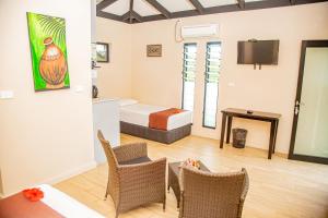 a hotel room with a bed and a table and chairs at Seatiki Resort Fiji On Coast in Sigatoka