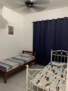 1 dormitorio con 2 camas y cortina azul en Let's Stay At Meritus, en Perai