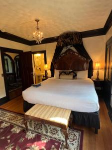 Schlafzimmer mit einem großen Bett mit einem Kopfteil aus Holz in der Unterkunft Manor House Inn in Norfolk