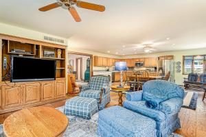 ein Wohnzimmer mit einem TV, Stühlen und einem Tisch in der Unterkunft Barton Cottage in New Buffalo