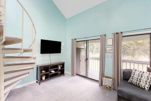 a living room with a staircase and a tv at Fairway Village Paradise in Myrtle Beach