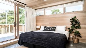 1 dormitorio con cama y ventana grande en Driftwood One, en Byron Bay