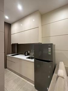 a kitchen with a refrigerator and a sink at SANG Hotel Apartment Sai Gon in Ho Chi Minh City