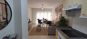 a kitchen and living room with a table and chairs at La Figar,apartamento con piscina, playa a 3km VUT-4390-AS in Llanes