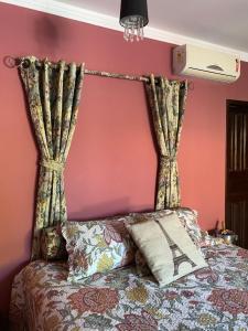 Schlafzimmer mit rosa Wänden und einem Bett mit Vorhängen in der Unterkunft Mansão Dubai in Santa Cruz Cabrália