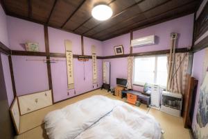 um quarto com uma cama num quarto com paredes roxas em 小樽民泊太田1号館 em Otaru