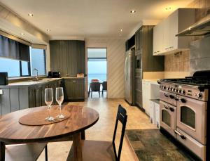 a kitchen with a table and two wine glasses at Arthurs Holiday Villa in Arthurs Seat