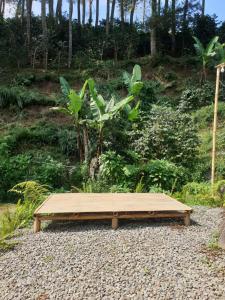 a wooden bench sitting on a pile of gravel at Kancah Nangkub in Pengalengan