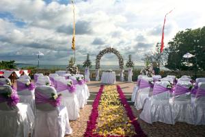a row of tables and chairs with flowers at Pelangi Bali Hotel & Spa in Seminyak
