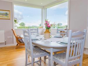 een witte eetkamer met een tafel en stoelen bij Hedge Betty-uk36797 in Foulsham