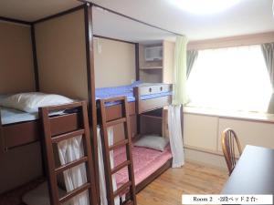 北谷町にある北谷 vacation house MALAPUAの二段ベッド2台と窓が備わる客室です。