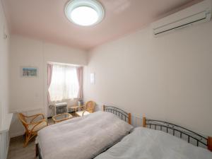 1 Schlafzimmer mit 2 Betten und einem Fenster in der Unterkunft 小樽民泊太田1号館 in Otaru