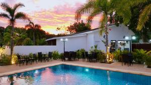 Villa con piscina, mesa y sillas en Jasmine Village en Rawai Beach