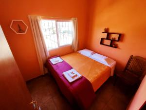 a small bedroom with a bed and a window at Hotel AEROPUERTO Jujuy in Perico