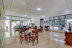 a dining room with tables and chairs and windows at OYO Life 92686 Lanaya Guesthouse Syariah in Salatiga