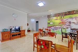 a living room with a tv and a table and chairs at OYO Life 92686 Lanaya Guesthouse Syariah in Salatiga