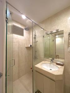 a bathroom with a sink and a glass shower at SANG Hotel Apartment Sai Gon in Ho Chi Minh City