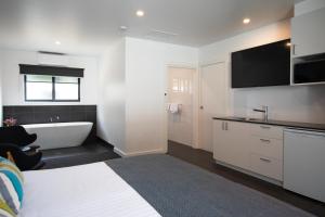 ブライトにあるBright Colonial Motelのバスルーム(ベッド1台、バスタブ付)、テレビが備わります。