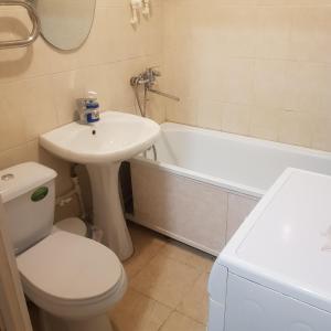 uma casa de banho com um lavatório, um WC e uma banheira em Однокомнатная квартира в Караганде em Karaganda
