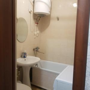 a bathroom with a sink and a toilet and a bath tub at Однокомнатная квартира в Караганде in Karagandy