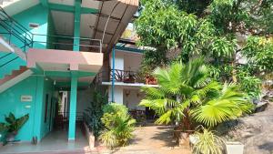 una casa con facciata blu e alberi di Sigiri Lion Lodge a Sigiriya