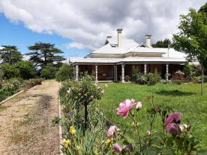 a house with a field of flowers in front of it at Alloway Bank in Bathurst