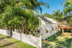 een wit huis met een hek en bomen bij Shirley Beach House, right in heart of Byron Bay, walking distance to town and most famous beaches, Pet Friendly in Byron Bay