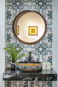 a bathroom with a sink and a mirror on a wall at Homestay Hang Tre 5min to Bar street in Hanoi