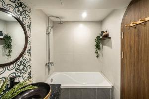 a bathroom with a tub and a sink and a mirror at Homestay Hang Tre 5min to Bar street in Hanoi +35 photos