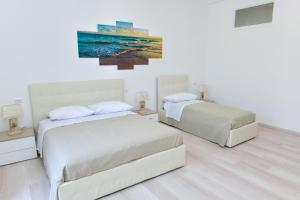 皮雅诺迪索伦托L'Aurora Azzurra -Luxury Suites Sorrento coast的一间卧室，墙上有两张床和一幅画