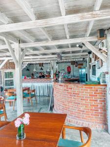 a dining room with a table and a brick wall at Tetebatu Flush Harmony in Tetebatu