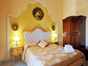 a bedroom with a large bed and a painting on the wall at La Dolce Vita - Luxury House in Agrigento