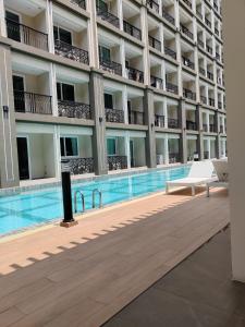 a swimming pool in front of a building at Romantic beach apartment芭堤雅水系高档酒店式公寓可做饭 in Jomtien Beach