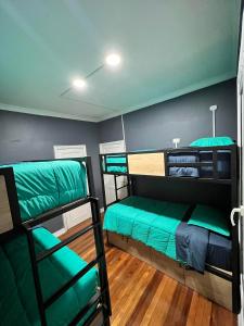two bunk beds in a room with green sheets at Casa Ribera Hotel Providencia in Santiago