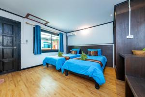 a bedroom with three beds with blue sheets at Phi Phi Long Beach Bungalow ( Had Yao) in Phi Phi Don