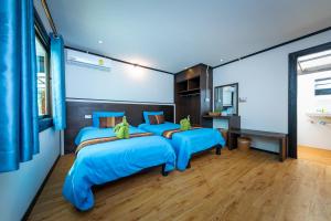 two beds in a room with blue sheets at Phi Phi Long Beach Bungalow ( Had Yao) in Phi Phi Don