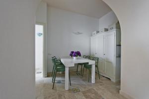 a dining room with a white table and green chairs at La Casa di Vania in Ravello