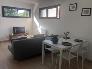 uma sala de estar com um sofá e uma mesa com cadeiras em Appartement paisible proche centre ville em Bron