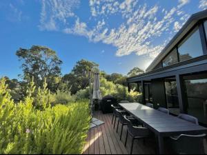 a deck with a table and chairs on a house at Villa Vines @ Rivendell Winery Estate in Yallingup Siding