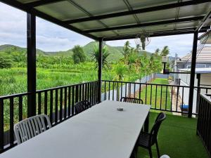 een witte tafel en stoelen op een balkon met uitzicht bij โคซี่ โฮมสเตย์ in Suan Phung