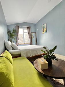 - une chambre avec un lit, une table et un canapé dans l'établissement Nhà An Đà Lạt, à Đà Lạt